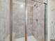 Walk-in shower boasts neutral tile, glass enclosure, and bench for added comfort at 227 Faith Avenue, Sanford, NC 27330