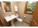 Neutral powder room featuring white fixtures, beige walls, and a framed window at 267 Bald Eagle Dr, Pittsboro, NC 27312