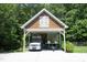Covered carport featuring a van and jet skis, surrounded by lush greenery and mature trees at 267 Bald Eagle Dr, Pittsboro, NC 27312