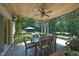 Inviting covered deck featuring a wood ceiling with fan, dining area, and beautiful views of the lush, green backyard at 267 Bald Eagle Dr, Pittsboro, NC 27312