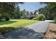 A long, paved driveway leads to a stately home surrounded by a lush, green lawn and mature trees at 267 Bald Eagle Dr, Pittsboro, NC 27312