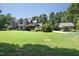 Well-maintained home with a lush green lawn, mature trees, detached garage, and a long driveway at 267 Bald Eagle Dr, Pittsboro, NC 27312