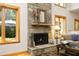 Living room fireplace with stone surround, hardwood floors, and bright windows at 267 Bald Eagle Dr, Pittsboro, NC 27312