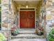 Inviting front entrance with double doors, stone accents, potted plants, and a welcoming light fixture at 267 Bald Eagle Dr, Pittsboro, NC 27312