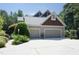 A three-car garage with neutral siding and trim, set amidst lush greenery and a well-maintained yard at 267 Bald Eagle Dr, Pittsboro, NC 27312