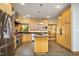 Bright eat-in kitchen with stainless steel appliances, wood cabinets, granite countertops, and tile floors at 267 Bald Eagle Dr, Pittsboro, NC 27312