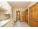 Laundry room features a sink, wood cabinets, tile floors, and a window at 267 Bald Eagle Dr, Pittsboro, NC 27312