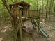 Elevated wooden treehouse with slide, ladder, and swing, offering an adventurous outdoor play area at 267 Bald Eagle Dr, Pittsboro, NC 27312