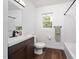 Clean bathroom with dark wood vanity, toilet, shower/tub, and a window with a view at 311 Troy St, Creedmoor, NC 27522