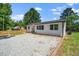 Charming renovated home with gravel drive, white painted brick, black roof and trim and lovely yard at 311 Troy St, Creedmoor, NC 27522