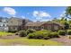 Backyard view of a brick home with a chimney and lush landscaping at 315 Crescent Dr, Clayton, NC 27520