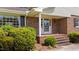 Charming brick home featuring a cozy front porch with brick steps and lush green bushes at 315 Crescent Dr, Clayton, NC 27520