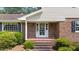 Classic brick front porch features white columns, a screen door, and traditional sconce lighting at 315 Crescent Dr, Clayton, NC 27520