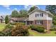 Charming brick home boasts a well-maintained lawn, complemented by mature landscaping and black window shutters at 315 Crescent Dr, Clayton, NC 27520