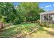 Picture of a large backyard with garden beds, mature trees, and a white picket fence at 3201 Sawyers Mill Dr, Apex, NC 27539