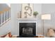 Close-up of the fireplace with sleek black tile, decorative mantel, and hardwood floors at 3201 Sawyers Mill Dr, Apex, NC 27539