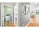 Hallway view of the laundry room and powder room with hardwood floors and gray paint at 3201 Sawyers Mill Dr, Apex, NC 27539