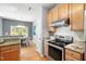 Galley kitchen features stainless steel appliances, granite counters, and wood cabinets at 3201 Sawyers Mill Dr, Apex, NC 27539