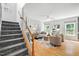 Spacious living room featuring neutral décor, large windows, and hardwood flooring by the stairs at 3201 Sawyers Mill Dr, Apex, NC 27539