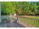Wooden deck with outdoor seating surrounded by mature trees and greenery at 3212 Marblewood Ct, Raleigh, NC 27604