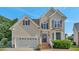 Charming two-story home with neutral siding, brick steps, a two-car garage, and manicured front landscaping at 3212 Marblewood Ct, Raleigh, NC 27604