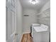 Bright laundry room with washer, dryer, shelving, and wood-look flooring at 3212 Marblewood Ct, Raleigh, NC 27604