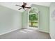 Bedroom featuring a large arch window, ceiling fan, and plush carpet flooring, providing a comfortable living space at 325 Millet Dr, Morrisville, NC 27560