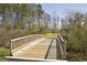 Scenic wooden bridge surrounded by trees in a natural setting, providing a peaceful walking experience at 325 Millet Dr, Morrisville, NC 27560