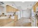 Well-lit kitchen featuring neutral countertops, white appliances, tile floors, and wooden cabinetry for ample storage at 325 Millet Dr, Morrisville, NC 27560