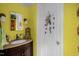 Bright yellow bathroom with white fixtures, dark vanity, mirror, and fun decor at 401 N Main St, Louisburg, NC 27549
