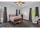 Bedroom with a queen bed, dark wood floors, vintage furniture, and natural light at 401 N Main St, Louisburg, NC 27549