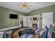 Bedroom featuring a decorative fireplace, green walls, and a mounted television at 401 N Main St, Louisburg, NC 27549