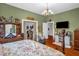 Green bedroom featuring vintage furniture, wooden floors, closet, and decorative touches at 401 N Main St, Louisburg, NC 27549