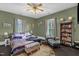 This bedroom boasts a colorful area rug, two windows, and a bookshelf at 401 N Main St, Louisburg, NC 27549