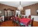 Bright dining room with wood floors, vintage hutch, crystal chandelier, and table with seating for 8 at 401 N Main St, Louisburg, NC 27549