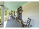 Spacious covered porch featuring rocking chairs and a hammock, offering a relaxing outdoor living space at 401 N Main St, Louisburg, NC 27549