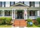 Charming front porch with patriotic decorations, brick steps, and welcoming entrance with black double doors at 401 N Main St, Louisburg, NC 27549