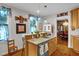 Charming kitchen with a breakfast bar featuring pendant lights, wood cabinets, and warm, natural lighting at 401 N Main St, Louisburg, NC 27549