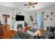 Cozy living room with a fireplace, ceiling fan, hardwood floors, and comfortable seating, creating an inviting space at 401 N Main St, Louisburg, NC 27549