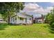 Quaint backyard with well-maintained lawn and view of the rear exterior of the home, including small sheds at 402 Poplar St, Graham, NC 27253