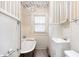 Bathroom with a tub, toilet, sink, and decorative wallpaper at 402 Poplar St, Graham, NC 27253