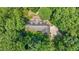 Aerial view of house nestled among lush trees with a long driveway at 4070 Swannie Coble Rd, Snow Camp, NC 27349