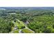 Scenic aerial view of property featuring lush greenery, private pond, and road access at 4070 Swannie Coble Rd, Snow Camp, NC 27349