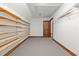 Attic storage space with built-in wooden shelving and carpeted floors at 4070 Swannie Coble Rd, Snow Camp, NC 27349