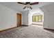 Well-lit bedroom featuring carpeted floors, a ceiling fan, and a window with natural wood trim at 4070 Swannie Coble Rd, Snow Camp, NC 27349