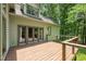 A wooden deck with doors leading inside, overlooking lush trees at 4070 Swannie Coble Rd, Snow Camp, NC 27349