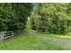 Gravel driveway leading through a lush, green, tree-lined landscape at 4070 Swannie Coble Rd, Snow Camp, NC 27349