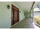 Close up of front porch with a beautifully crafted wooden front door and overhead lighting at 4070 Swannie Coble Rd, Snow Camp, NC 27349