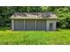 Three-car detached garage with gray doors and a door located to the right at 4070 Swannie Coble Rd, Snow Camp, NC 27349