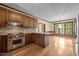 Bright eat-in kitchen area with chandelier, wooden cabinetry, and stainless steel appliances at 4070 Swannie Coble Rd, Snow Camp, NC 27349
